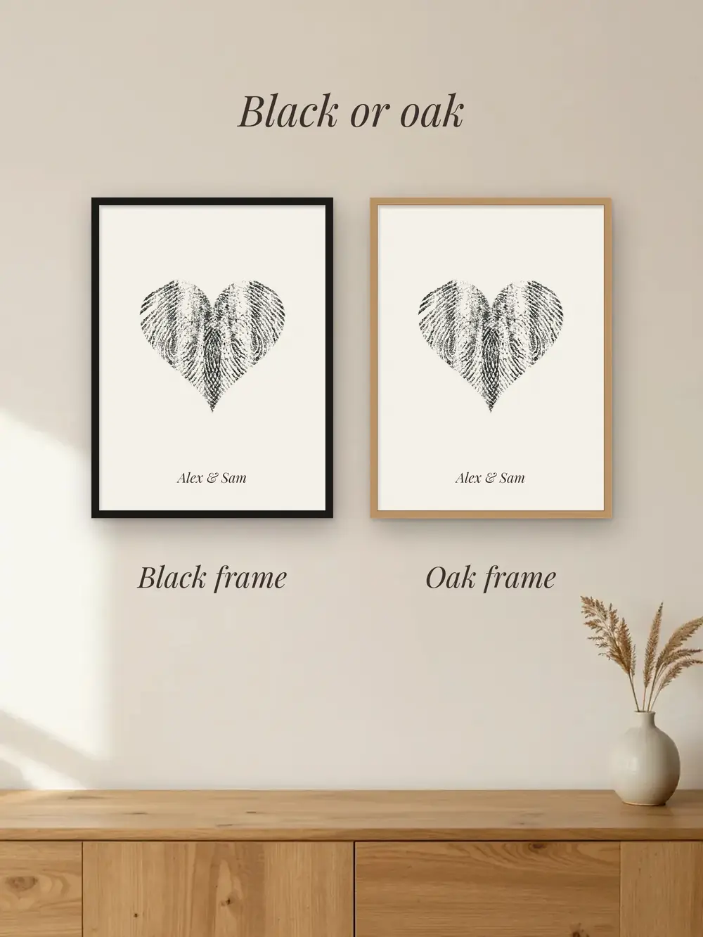 A fingerprint heart in a black frame next to the same heart in an oak frame