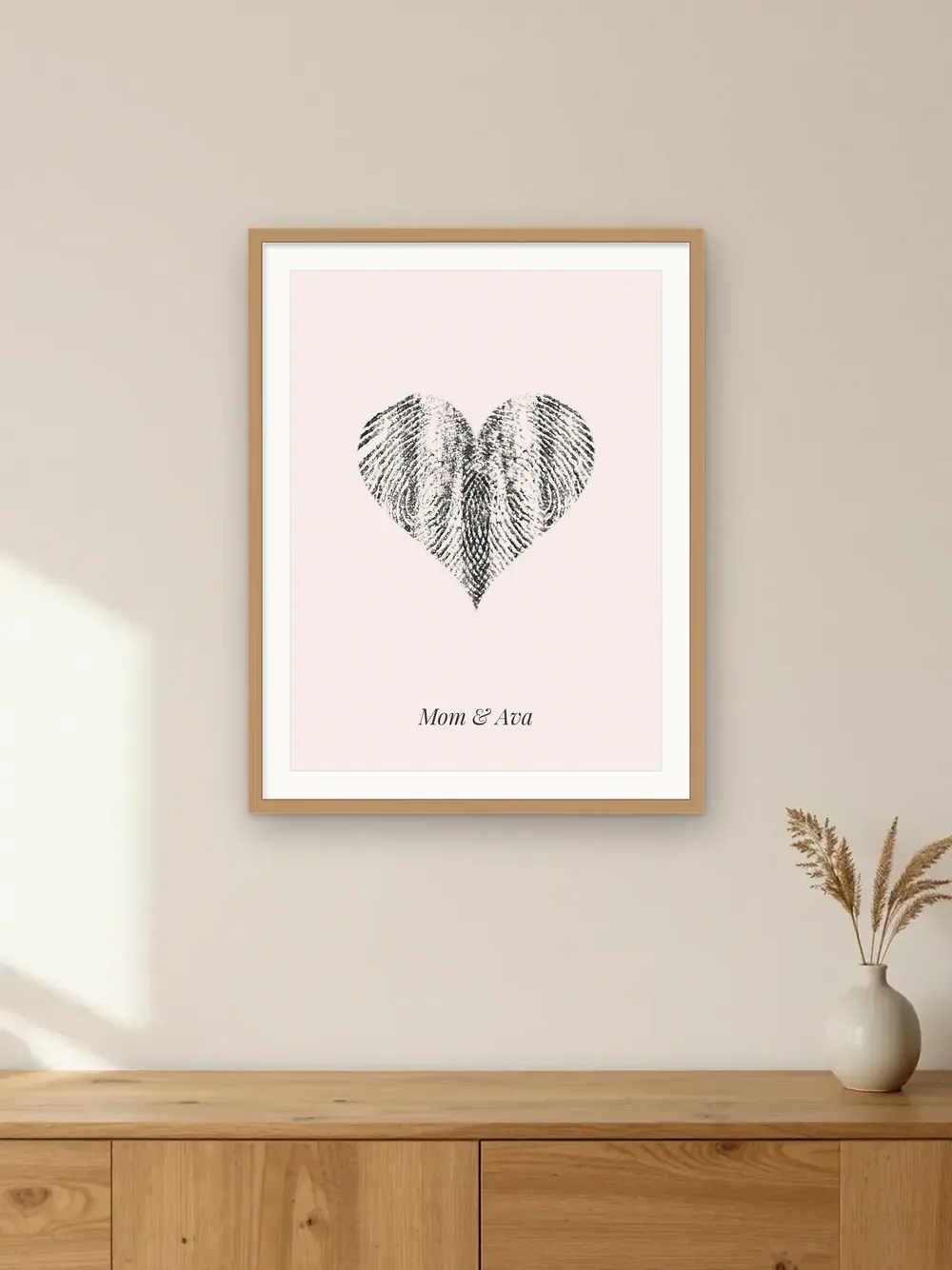 Mother’s Day gift mockup: a fingerprint heart made from two real ink prints, in an oak frame labelled “Mom & Ava”